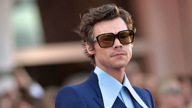 Harry Styles wears a navy blue suit and oversized collared shirt and sunglasses to the Venice International Film Festival 2022.
