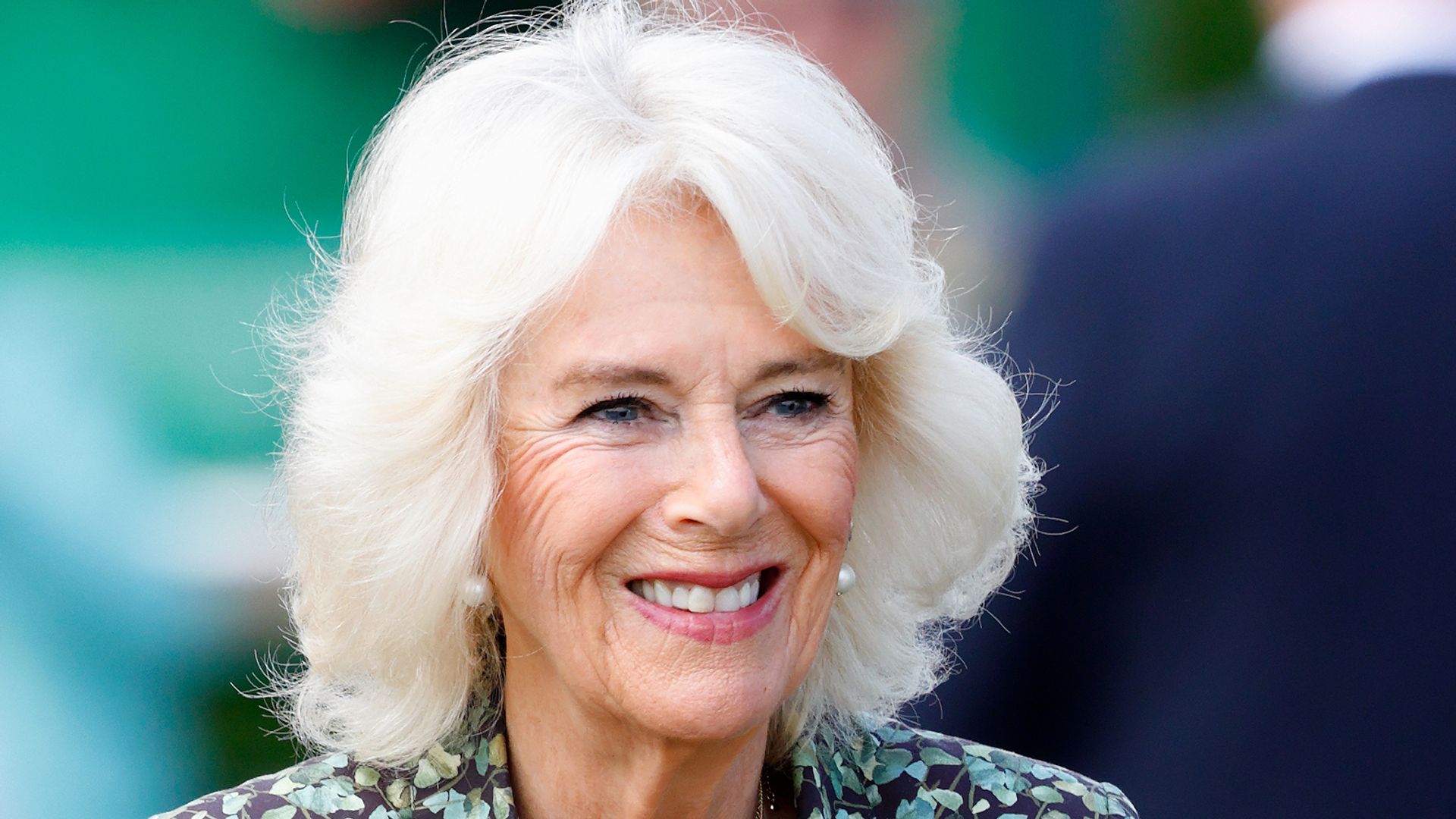 Queen Camilla smiling in floral dress