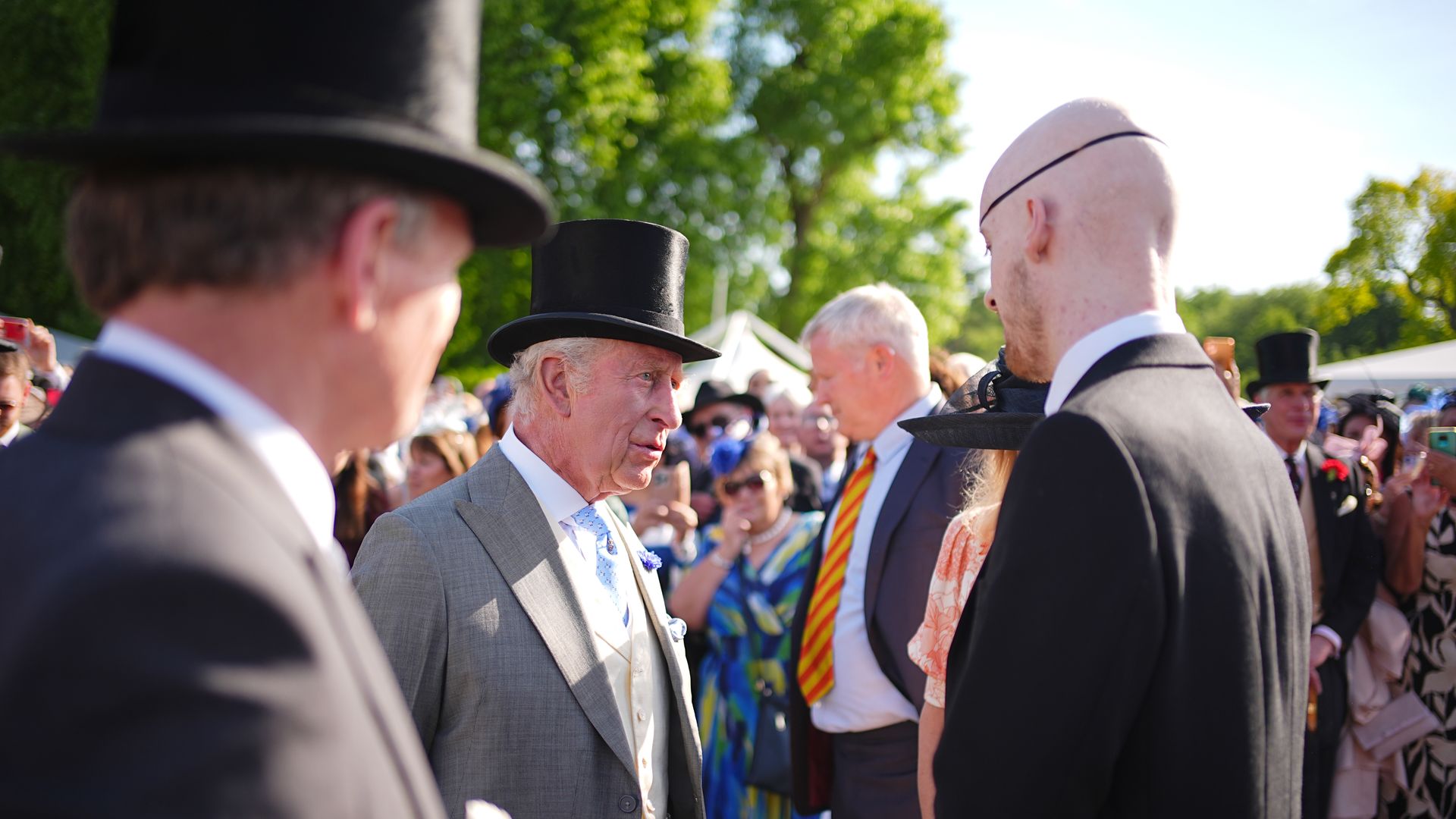 King Charles speaking to a cancer patient at Buckingham Palace