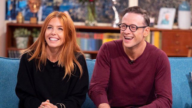 Kevin Clifton and Stacey Dooley laughing on a sofa