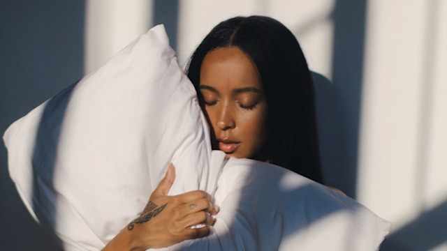 woman hugging a big white fluffy pillow 