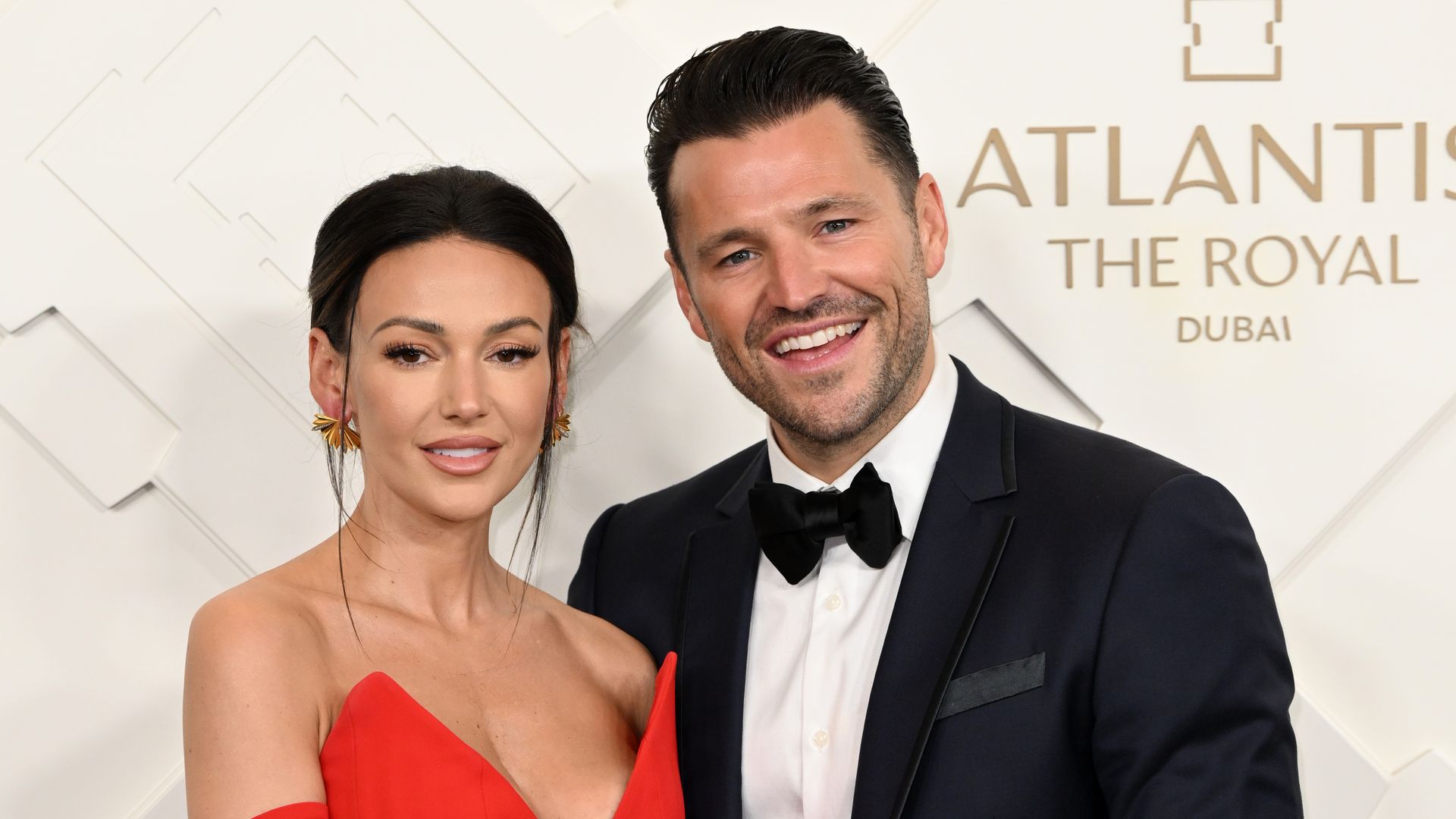 Michelle Keegan in a red dress next to Mark Wright in a tuxedo