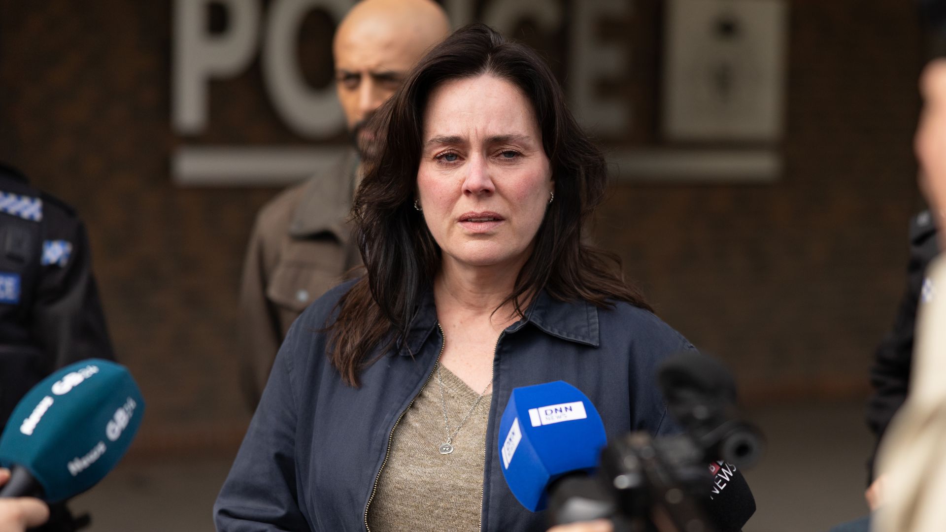 woman standing in front of microphones