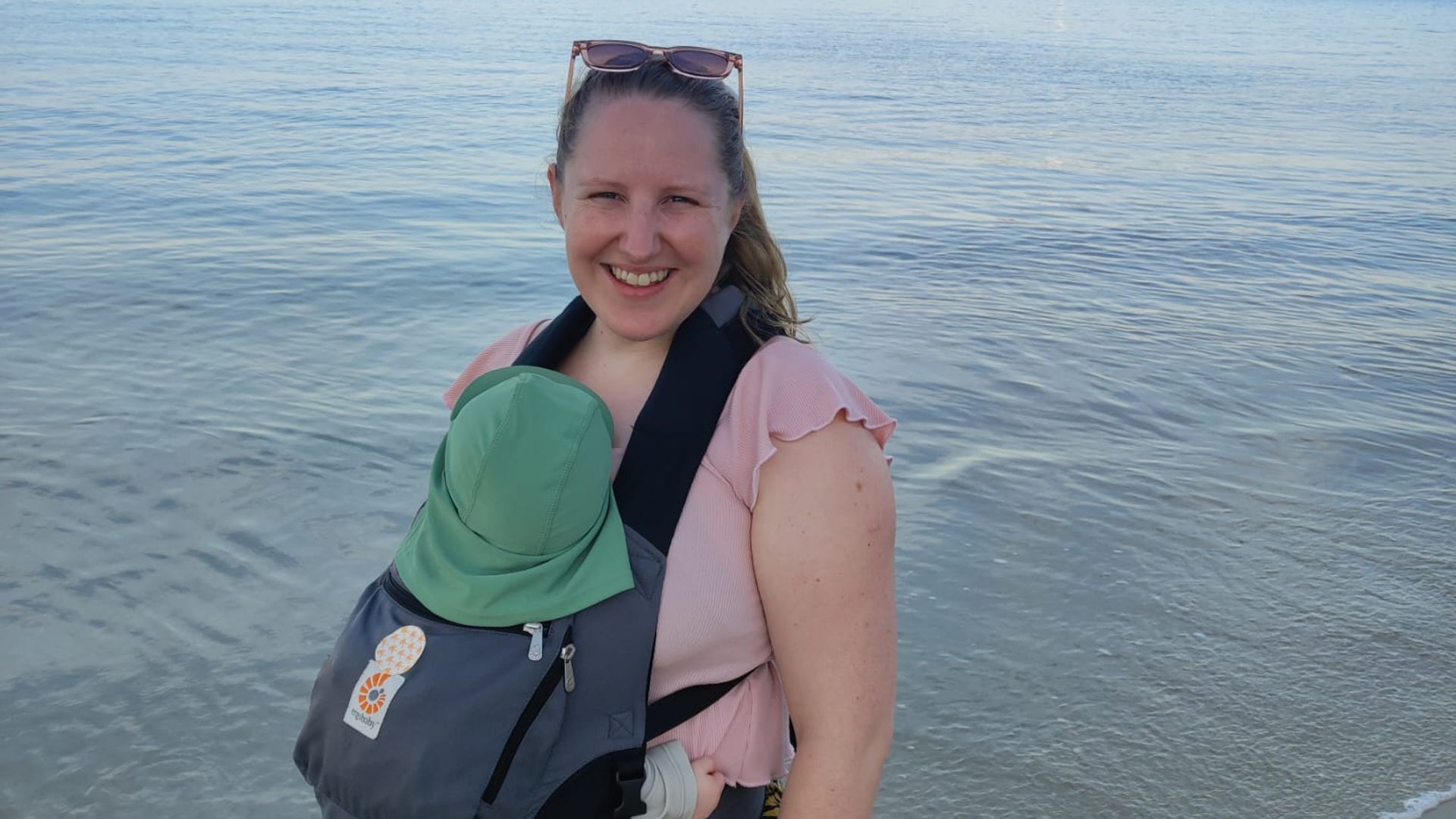 Woman in beach with baby in a carrier