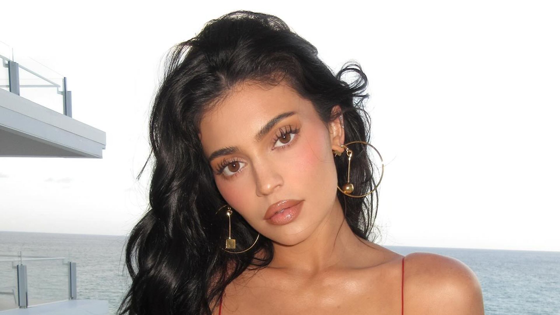 Kylie Jenner poses in a red mini dress on a balcony in Miami