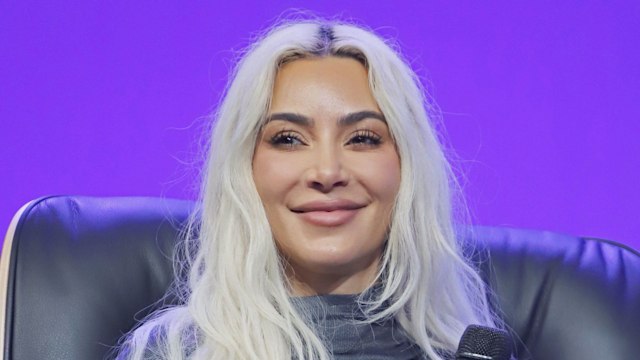 Kim Kardashian smiling in a grey top
