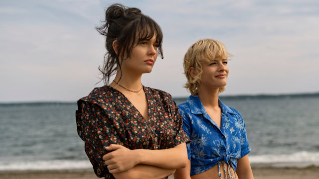 two teenage girls standing on beach 