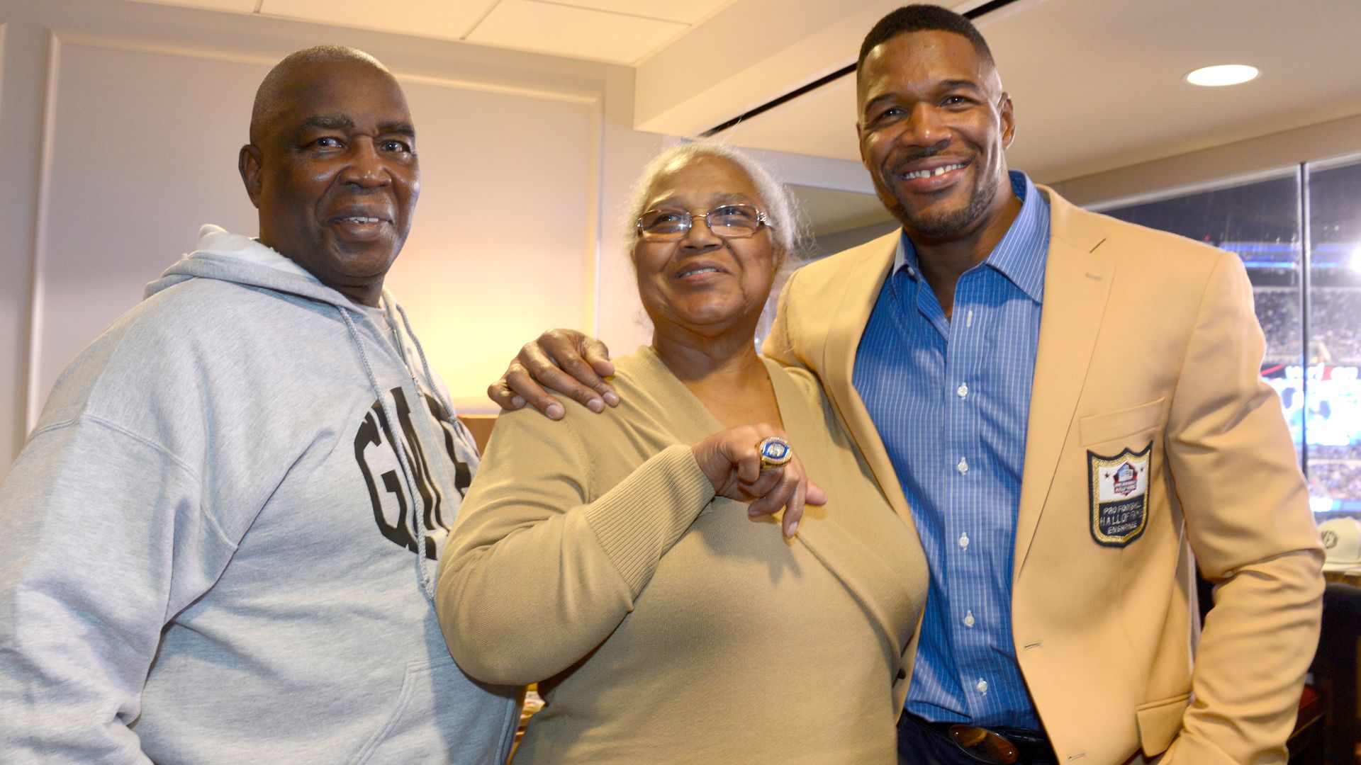 Michael Strahan smiling with his dad Gene Strahan and his mom Louise Strahan in 2014