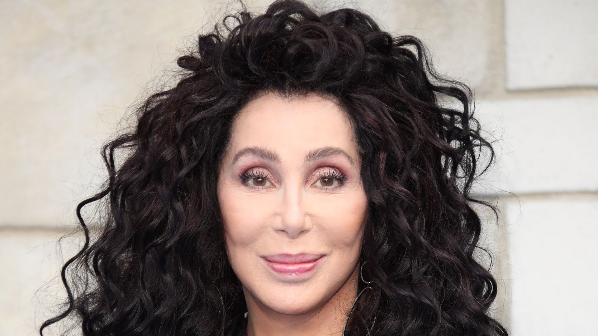 Cher smiling with her hair in tight curls 
