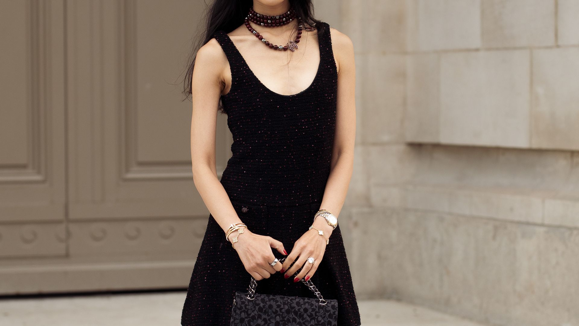  Rebecca Ma wears black mini dress and black Chanel bag with flowers pattern and black necklace outside Chanel show during the Haute Couture Fall/Winter 2025/2026 as part of Paris Fashion Week 
