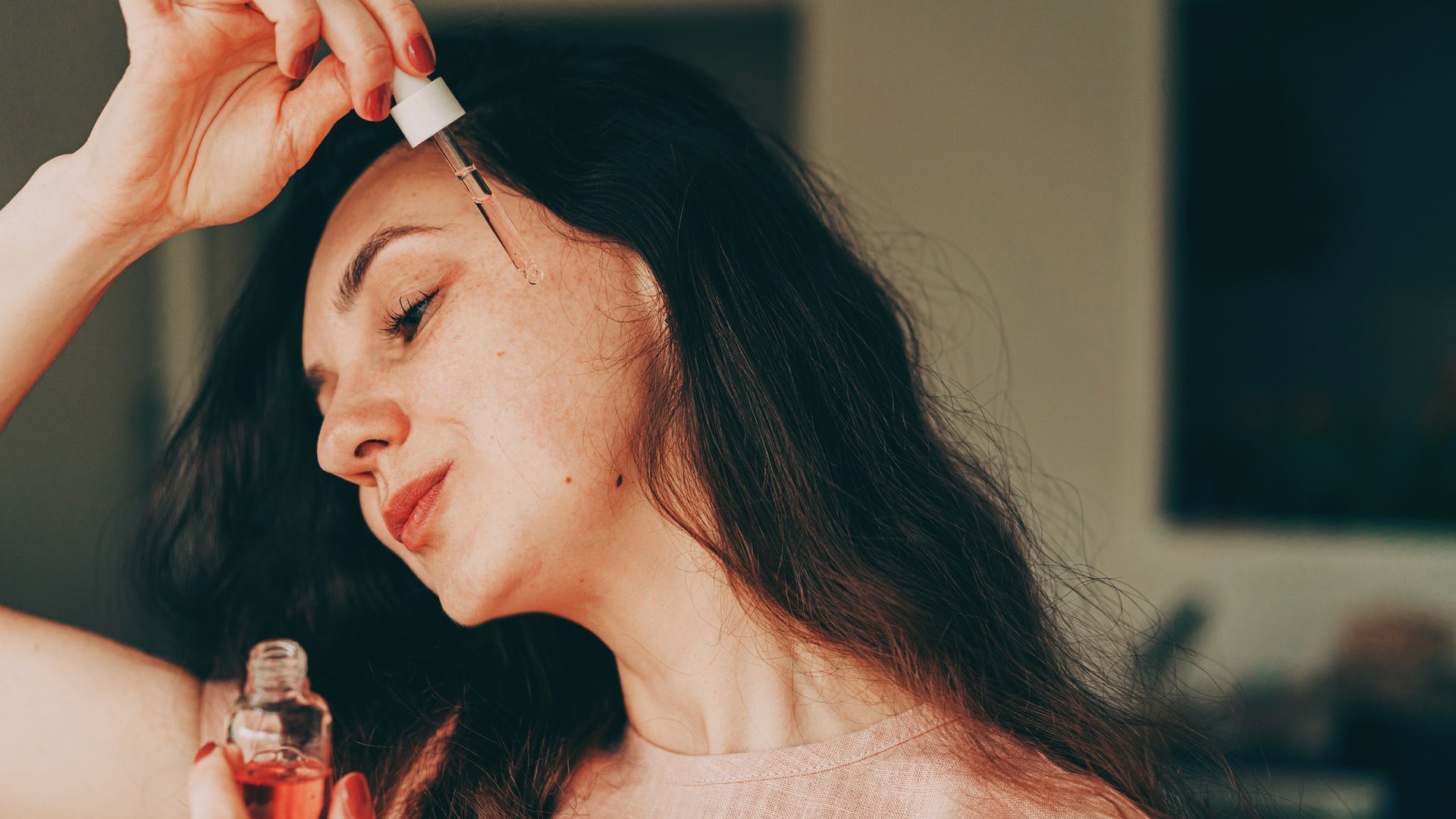 woman applies facial cream and enjoys skincare routine