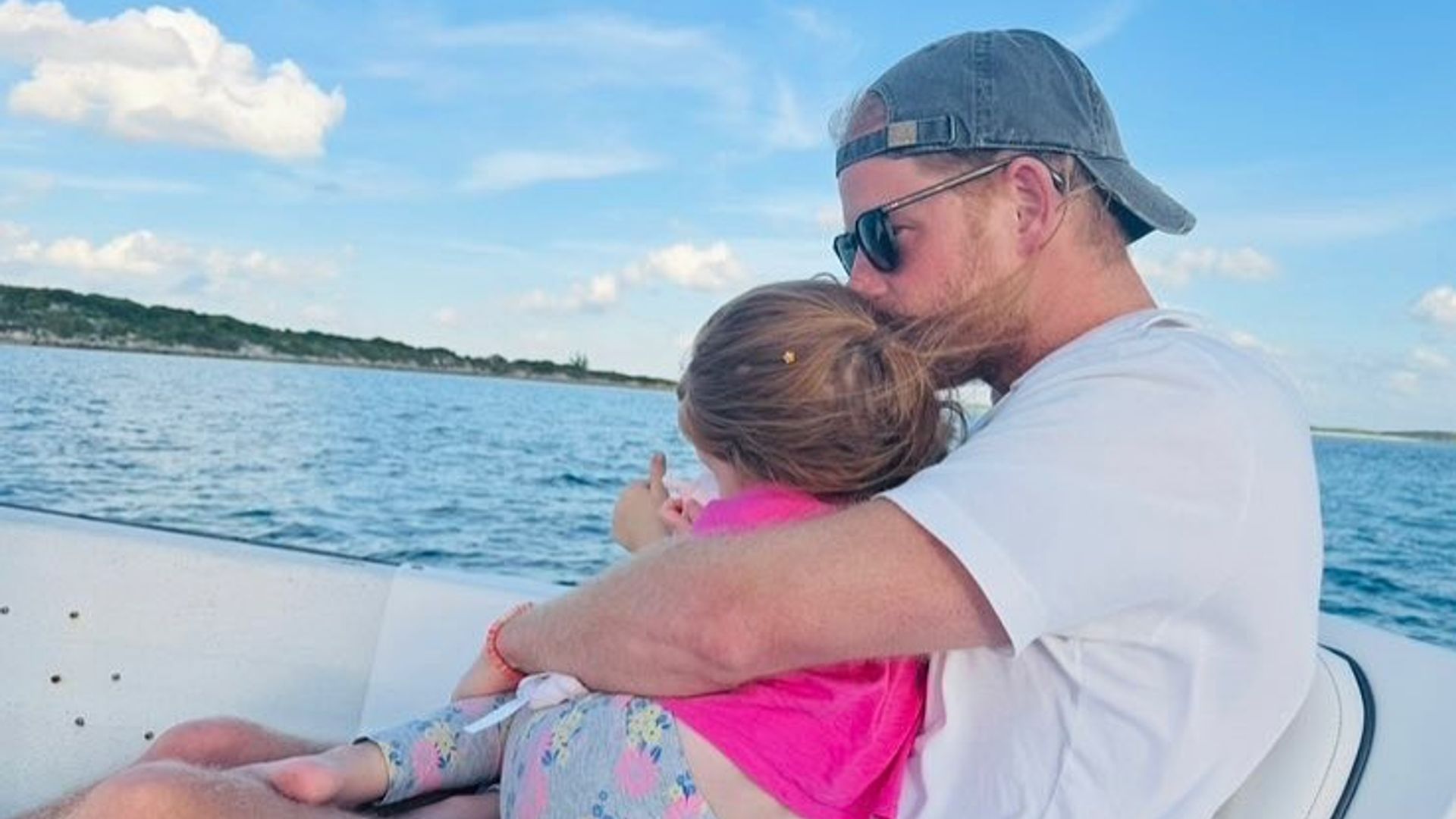 Prince Harry cuddling Lilibet on a boat