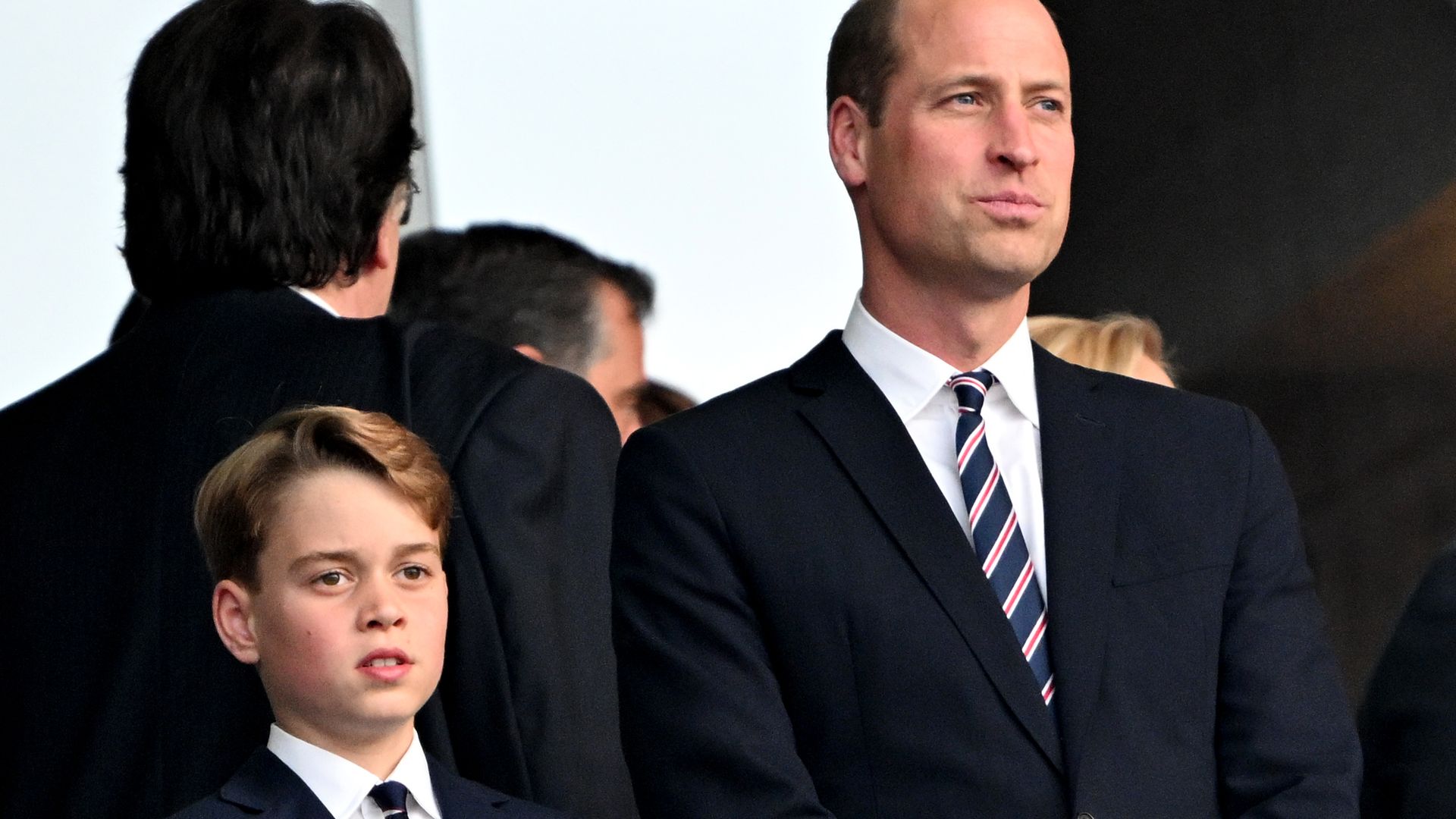 Prince William (r), Prince of Wales, and his son Prince George stand in the stands before the start of the match