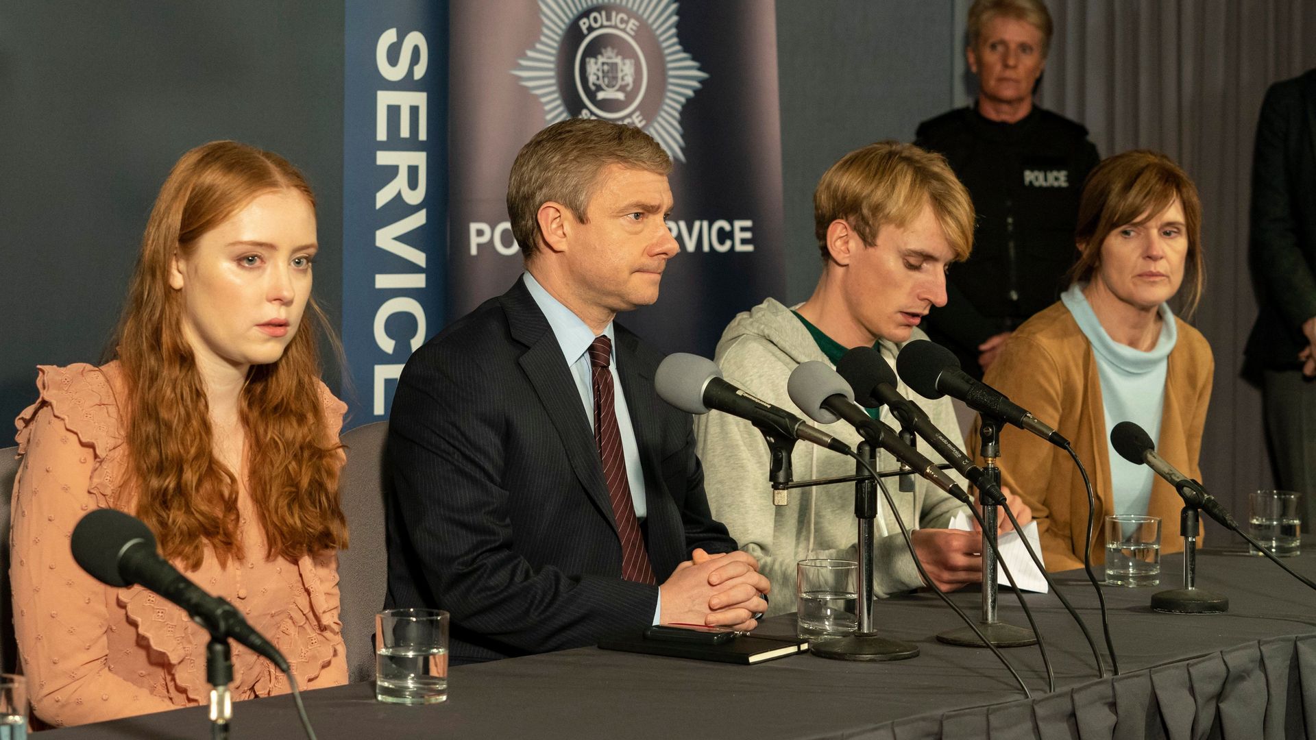 four people sitting at press conference
