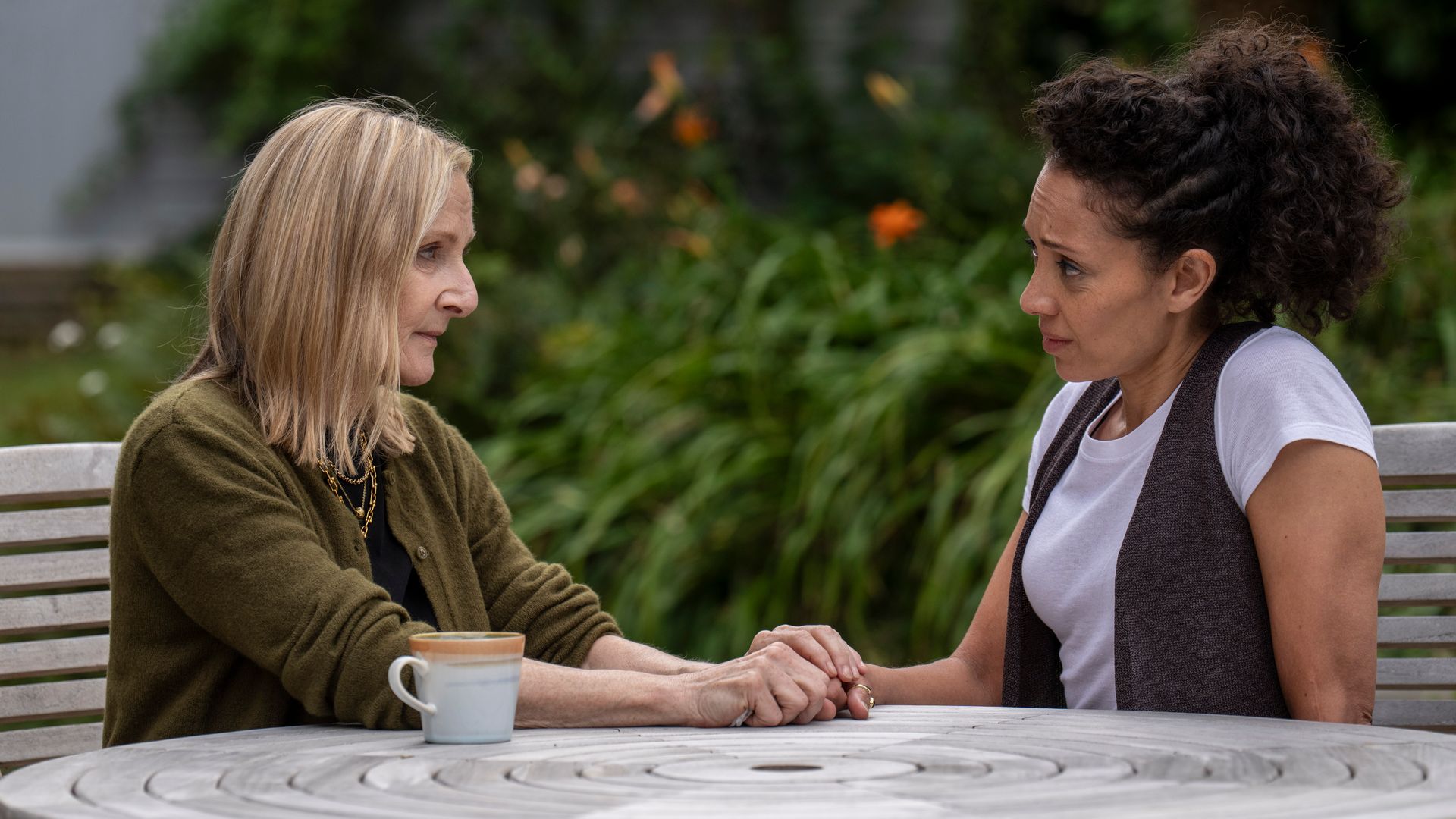 two women sitting at garden table