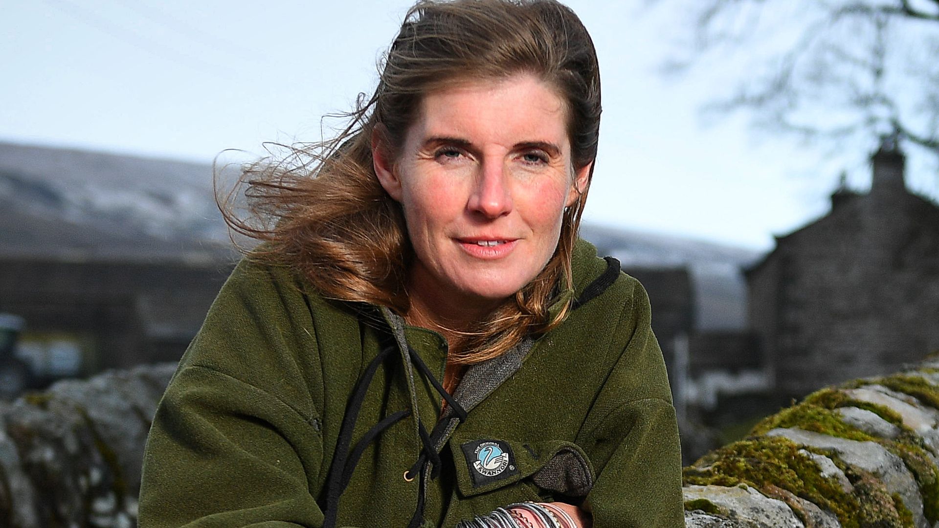 Amanda Owen in a green coat on a bridge