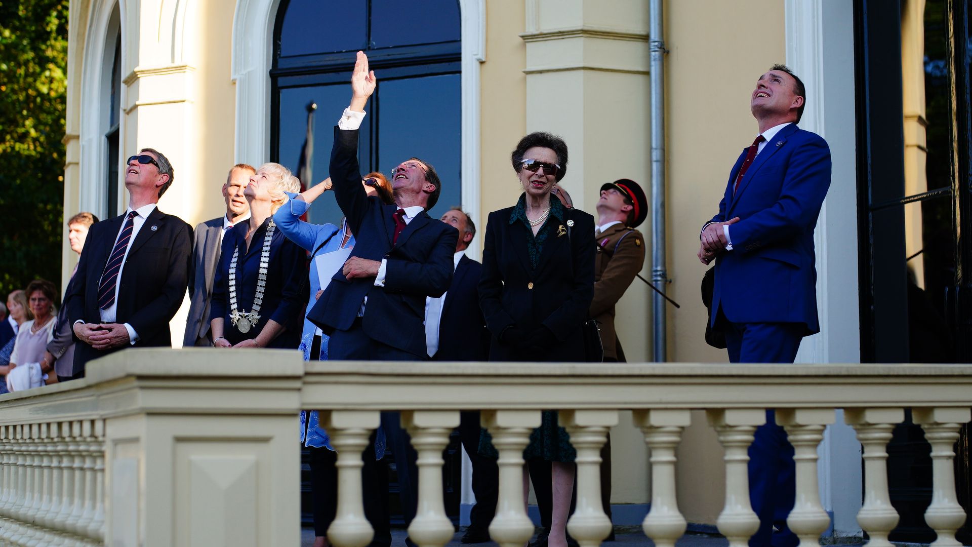 group of people standing on balcony area