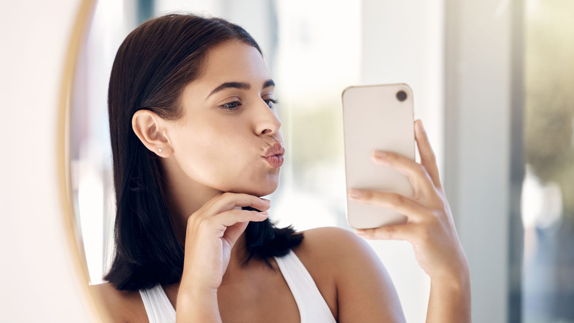  woman blowing self kiss in mirror selfie