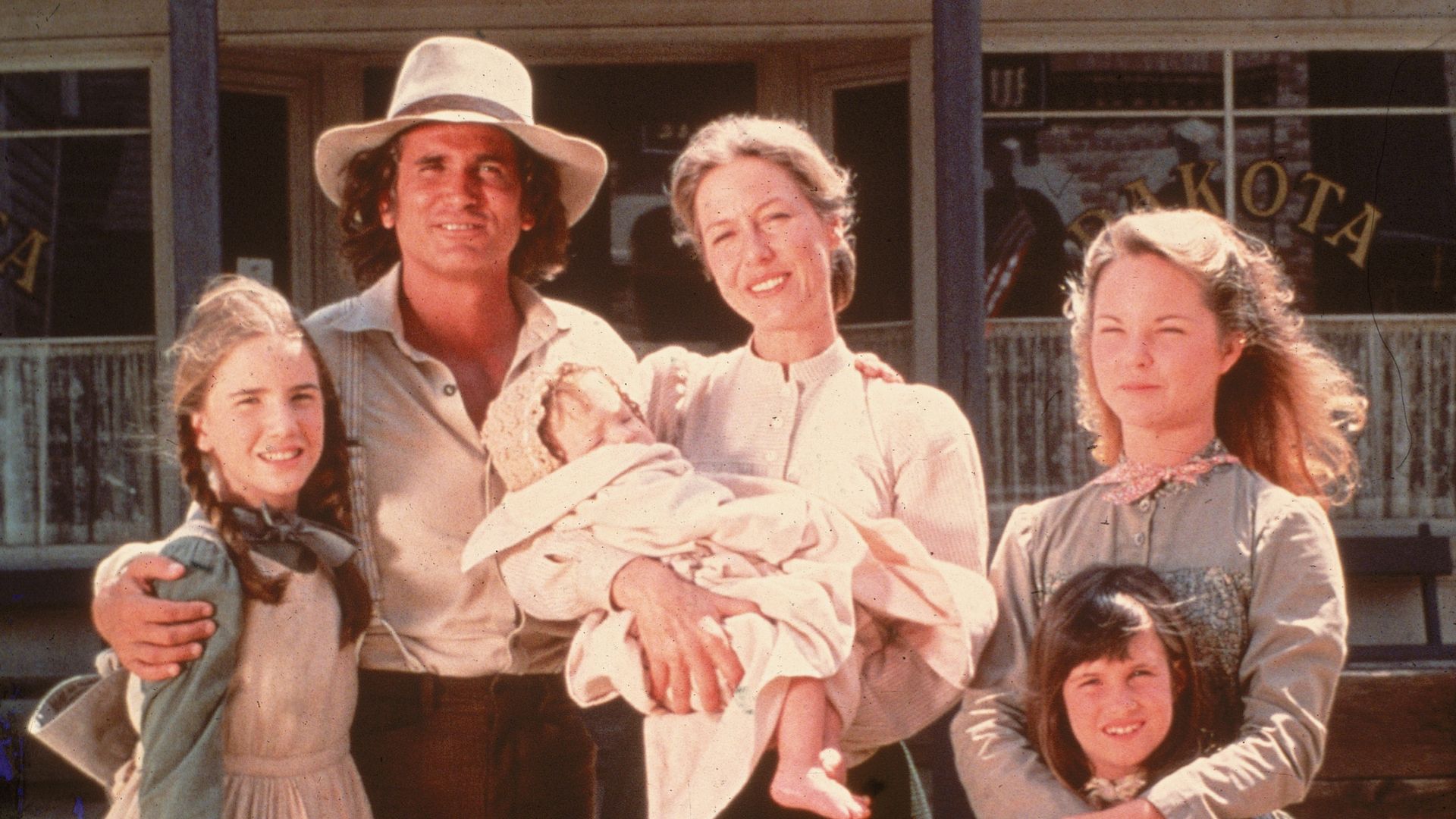 The cast of the television series 'Little House on the Prairie' with a dog on the set of the show, mid 1970s. Clockwise from left: American actors Melissa Gilbert, Michael Landon (1936 - 1991), Karen Grassle, who holds an unidentified baby, Melissa Sue Anderson, and Lindsay or Sidney Greenbush.