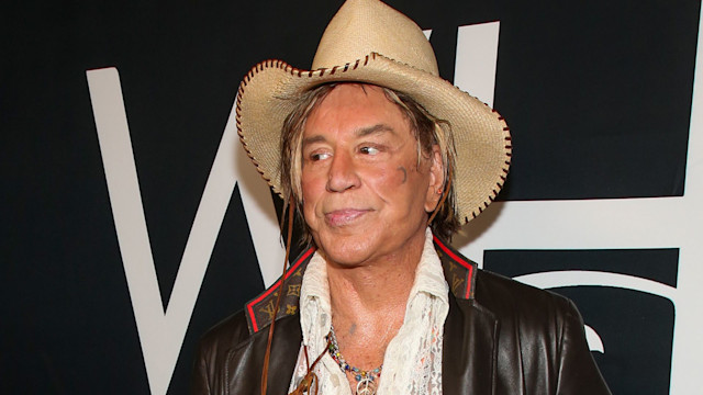 Mickey Rourke wearing a leather jacket and cowboy hat 