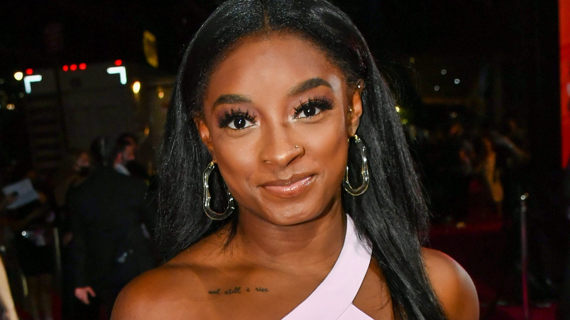 Simone Biles in a one-shoulder dress and hoop earrings on the red carpet