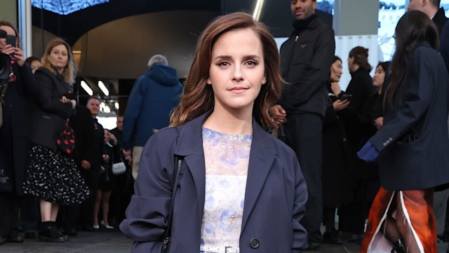 Emma Watson wearing a navy coat and a frill-lined mini dress