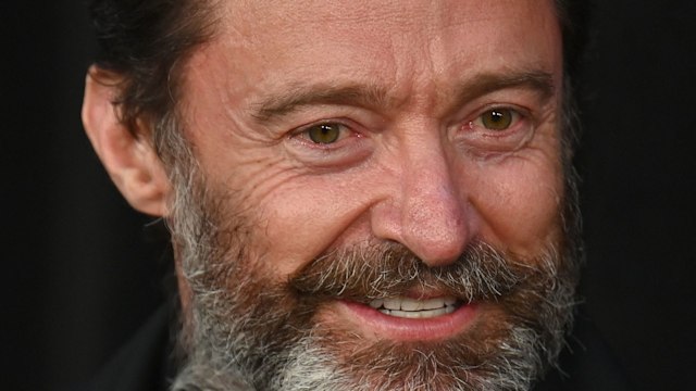 Hugh Jackman smiling slightly in black