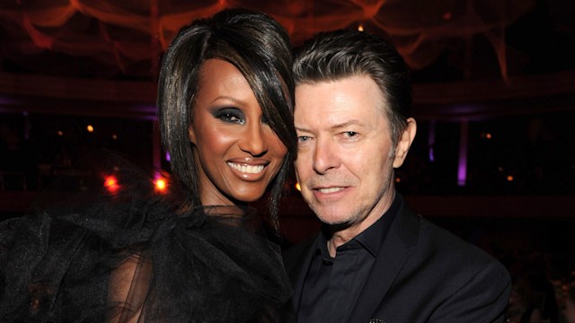 Iman and David Bowie hugging in black outifts