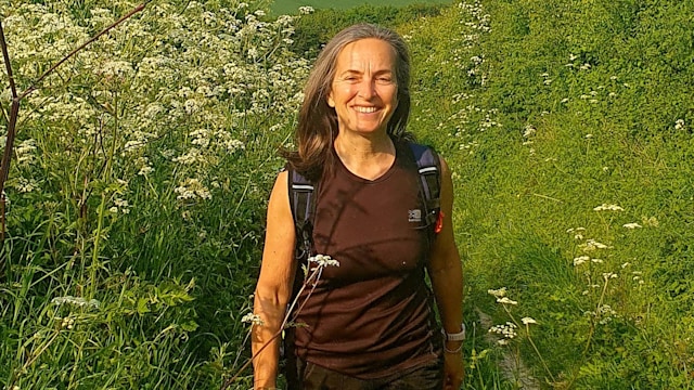 woman walking through a fresh green field smiling 