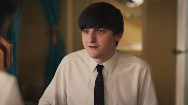 Teenager in shirt and tie sitting at kitchen table