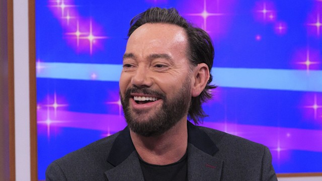 Craig Revel Horwood sitting on a sofa