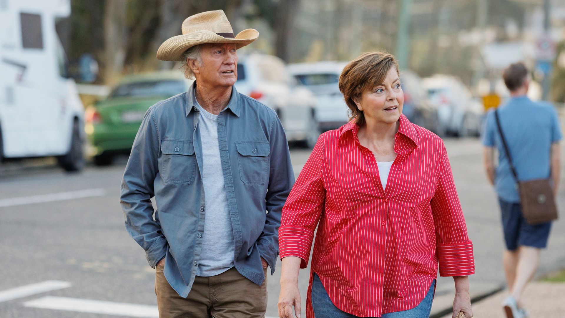 man and woman walking down street