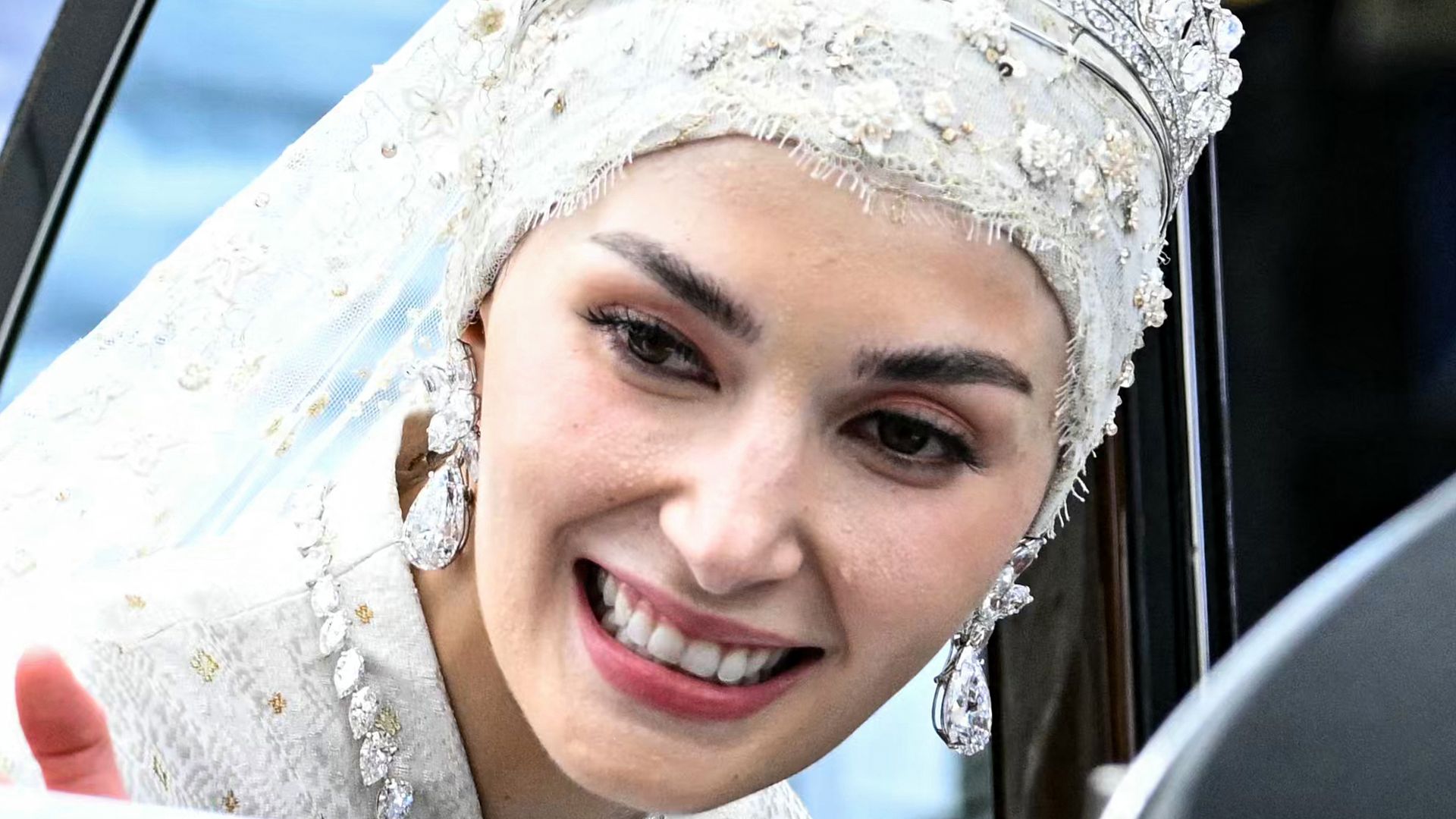 Prince Abdul Mateen and Yang Mulia Anisha Rosnah wave from their car during the wedding procession