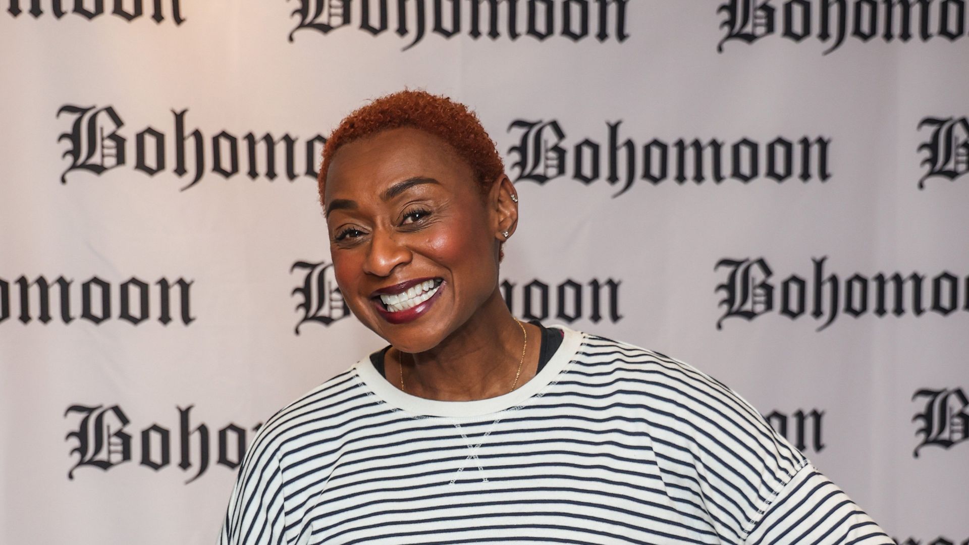 Michelle Griffith-Robinson in a striped top smiling while attending as British jewellery brand Bohomoon host a yoga & pilates event at FLOW Ldn