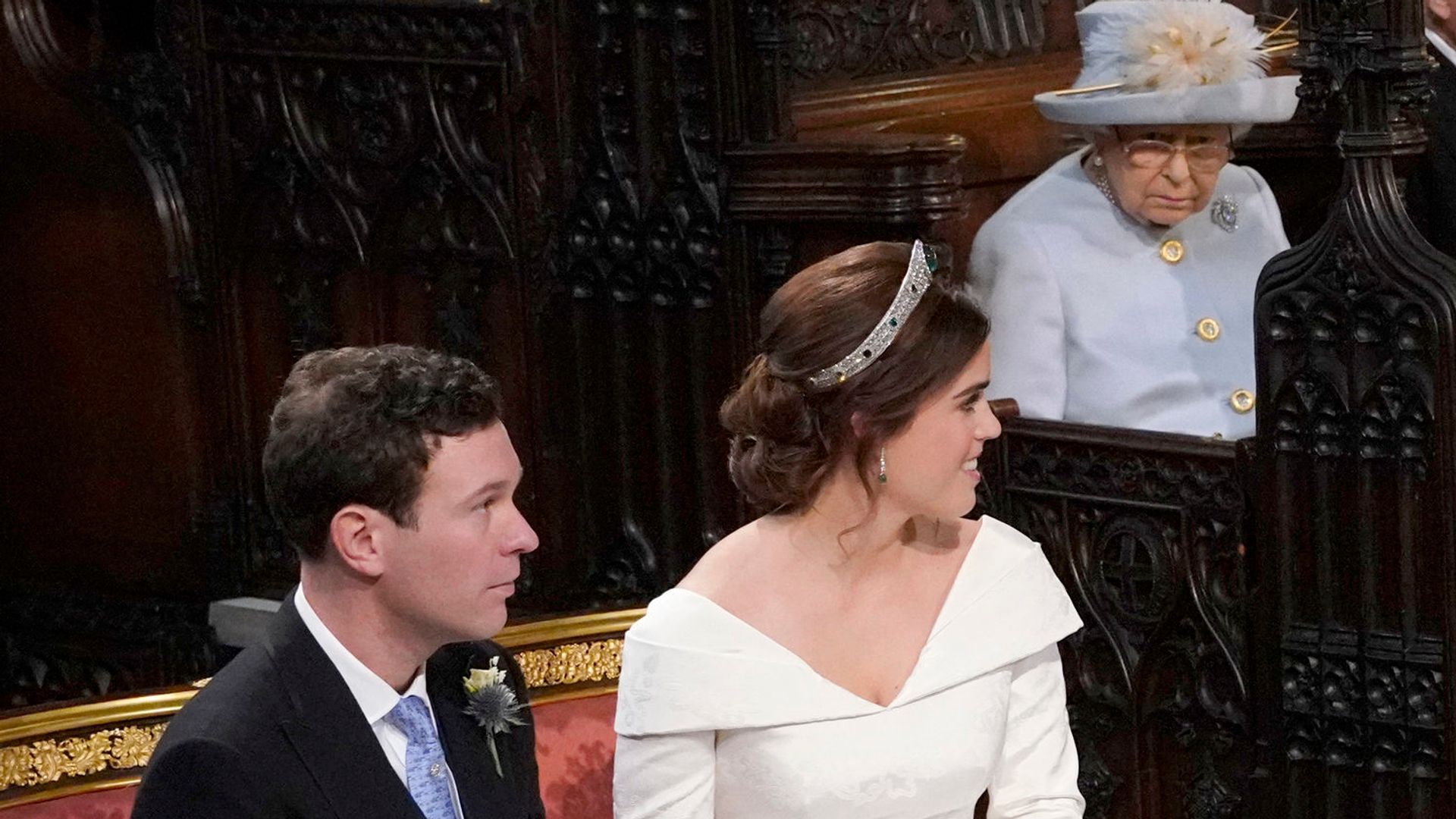 Princess Eugenie and her husband Jack Brooksbank look back towards Queen Elizabeth II on their wedding day
