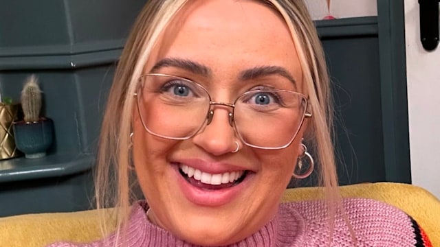 woman smiling in red and pink jumper 