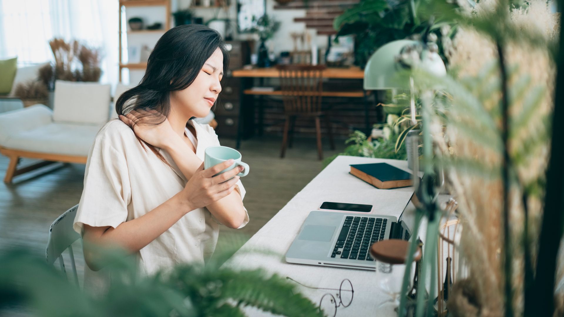 Asian woman struggling with using laptop at home