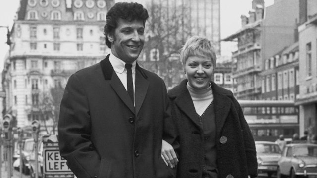 Black-and-white photo of Tom Jones and wife Linda in a street