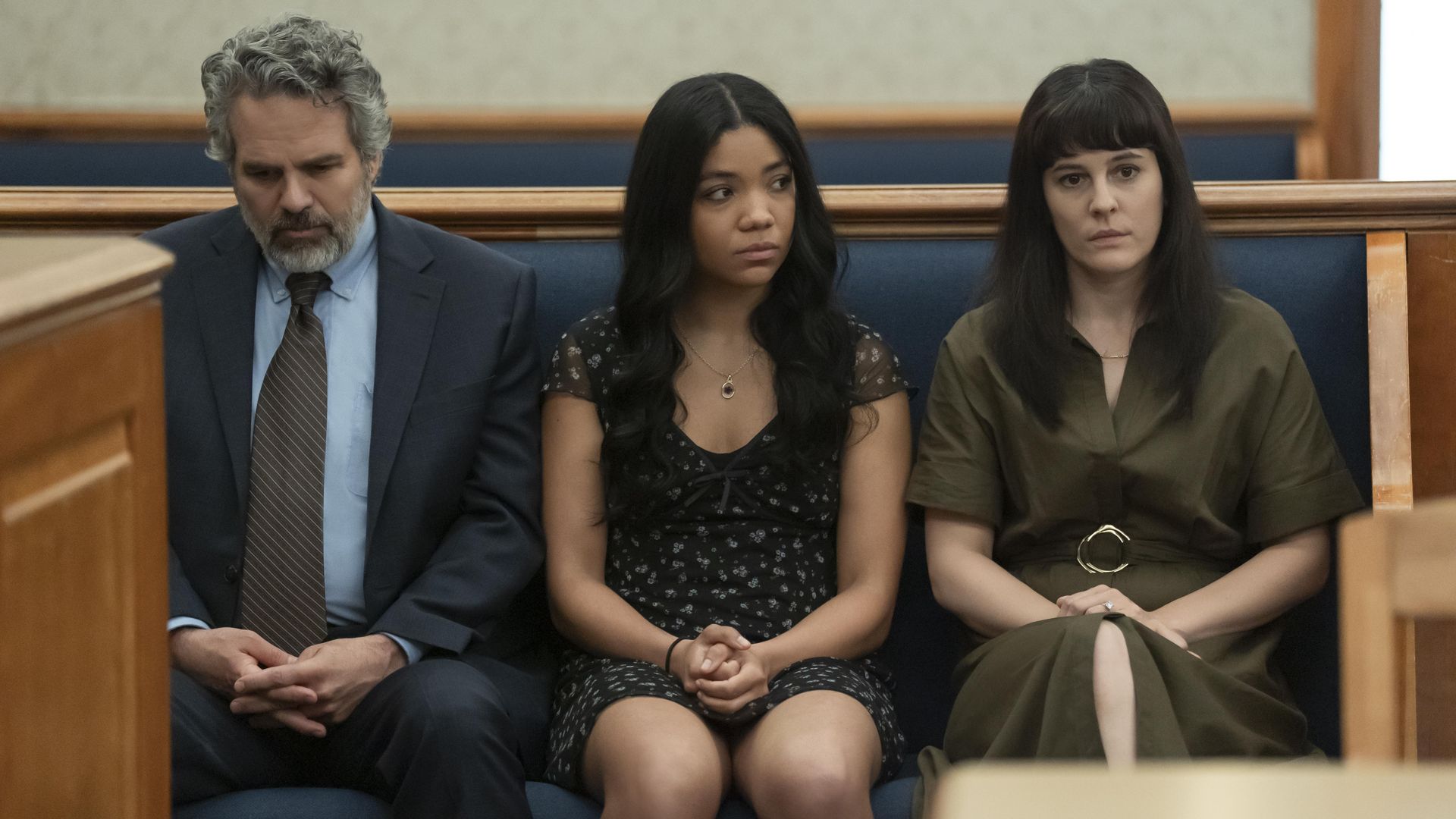 three people sitting in court room