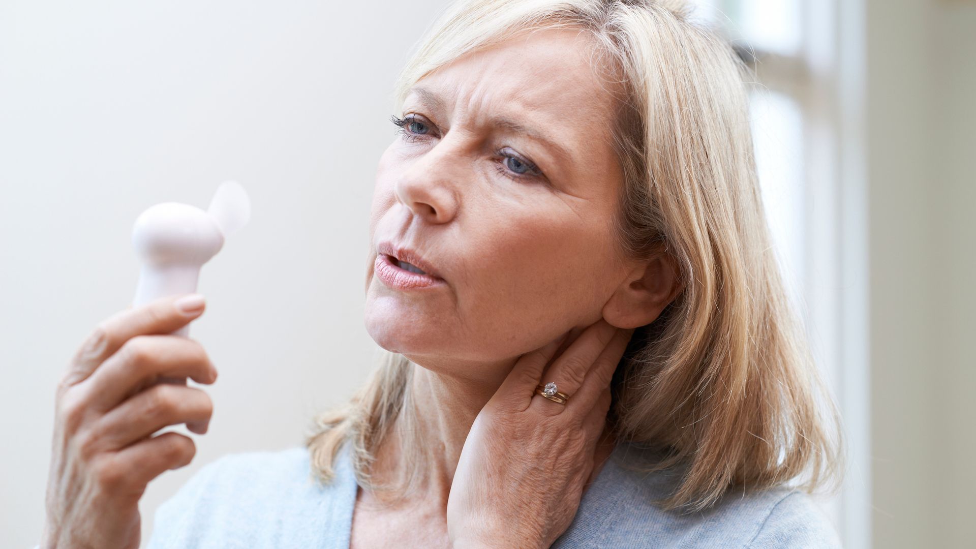 woman holding fan during hot flush