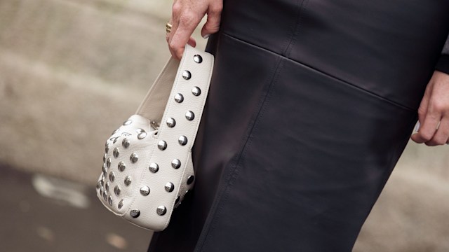 A guest wears black long skirt, grey cropped jacket and white bag outside The Courreges show during Womenswear Spring/Summer 2025 as part of  Paris Fashion Week on September 25, 2024 in Paris, France. (Photo by Raimonda Kulikauskiene/Getty Images)