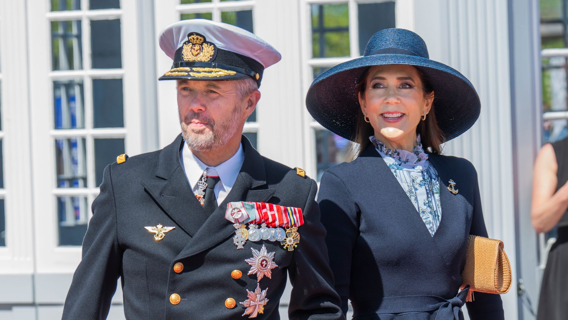 King Frederik in a naval uniform and Queen Mary in a blue outfit