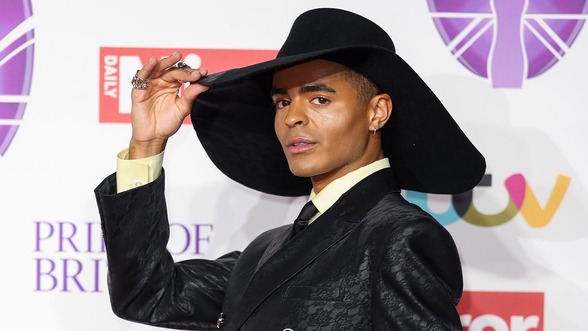 Layton Williams wearing a statement hat and black suit at the Pride of Britain Awards 2023