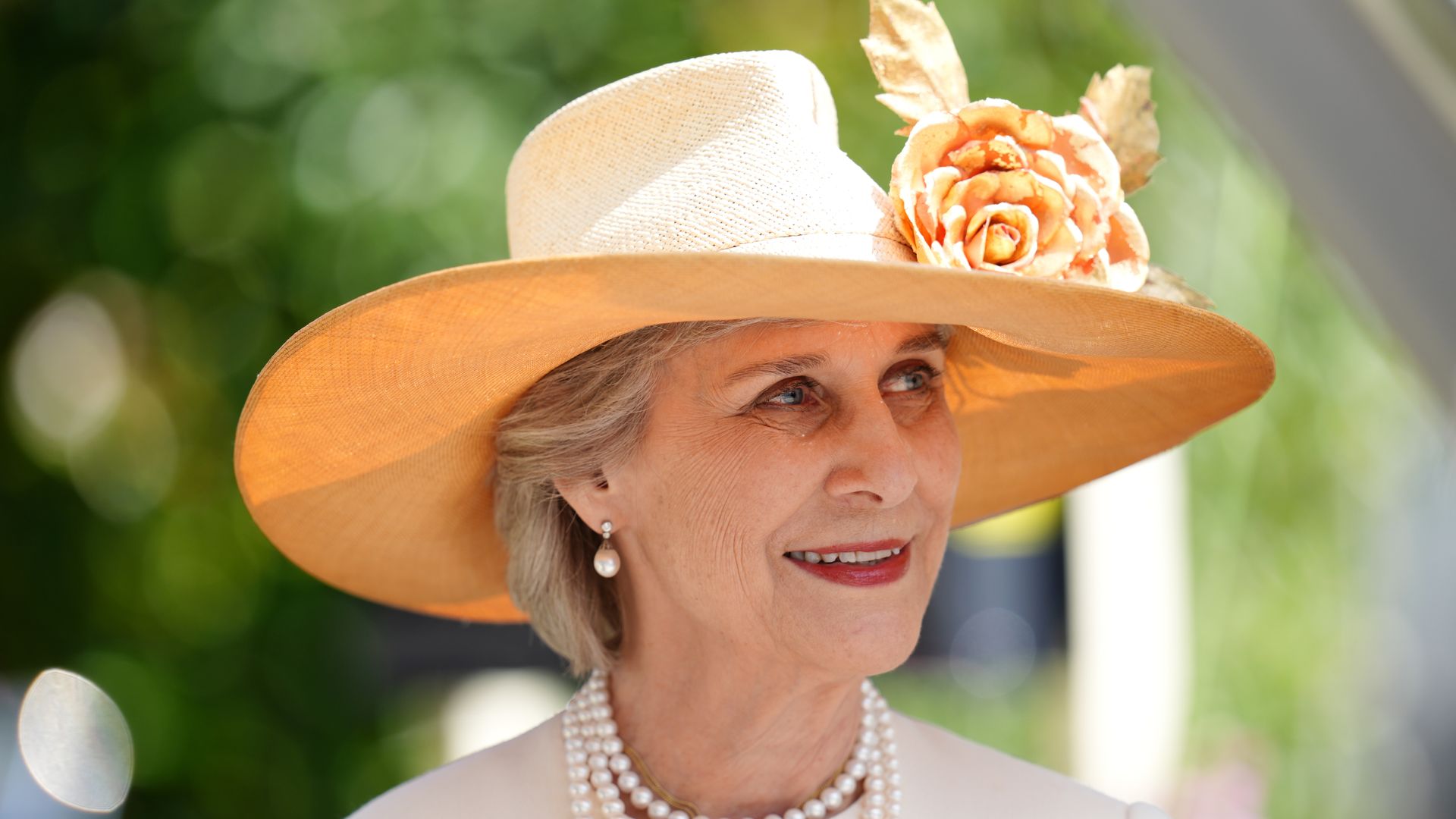 The Duchess of Gloucester wearing cream coat, pearls and floral hat at Royal Ascot