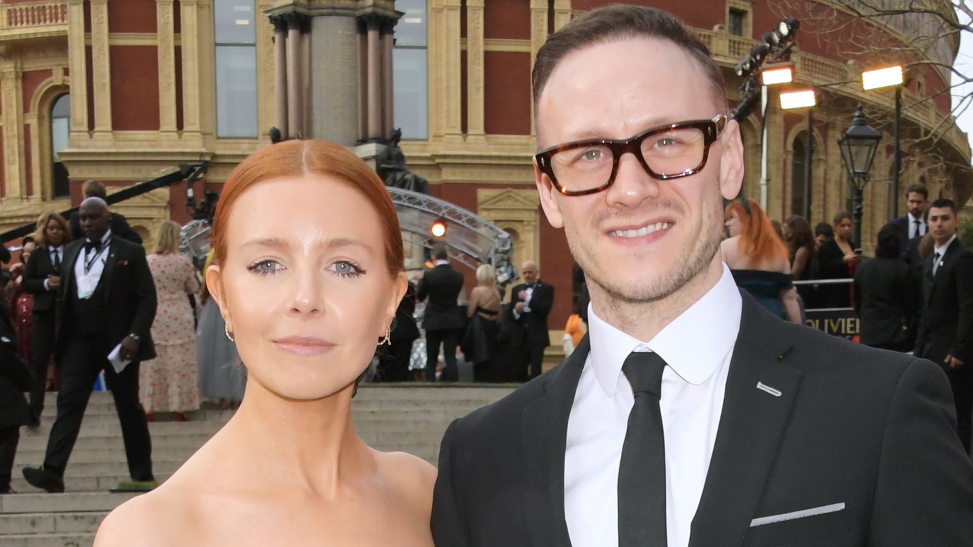 Stacey Dooley in black dress stood with Kevin Clifton in a suit