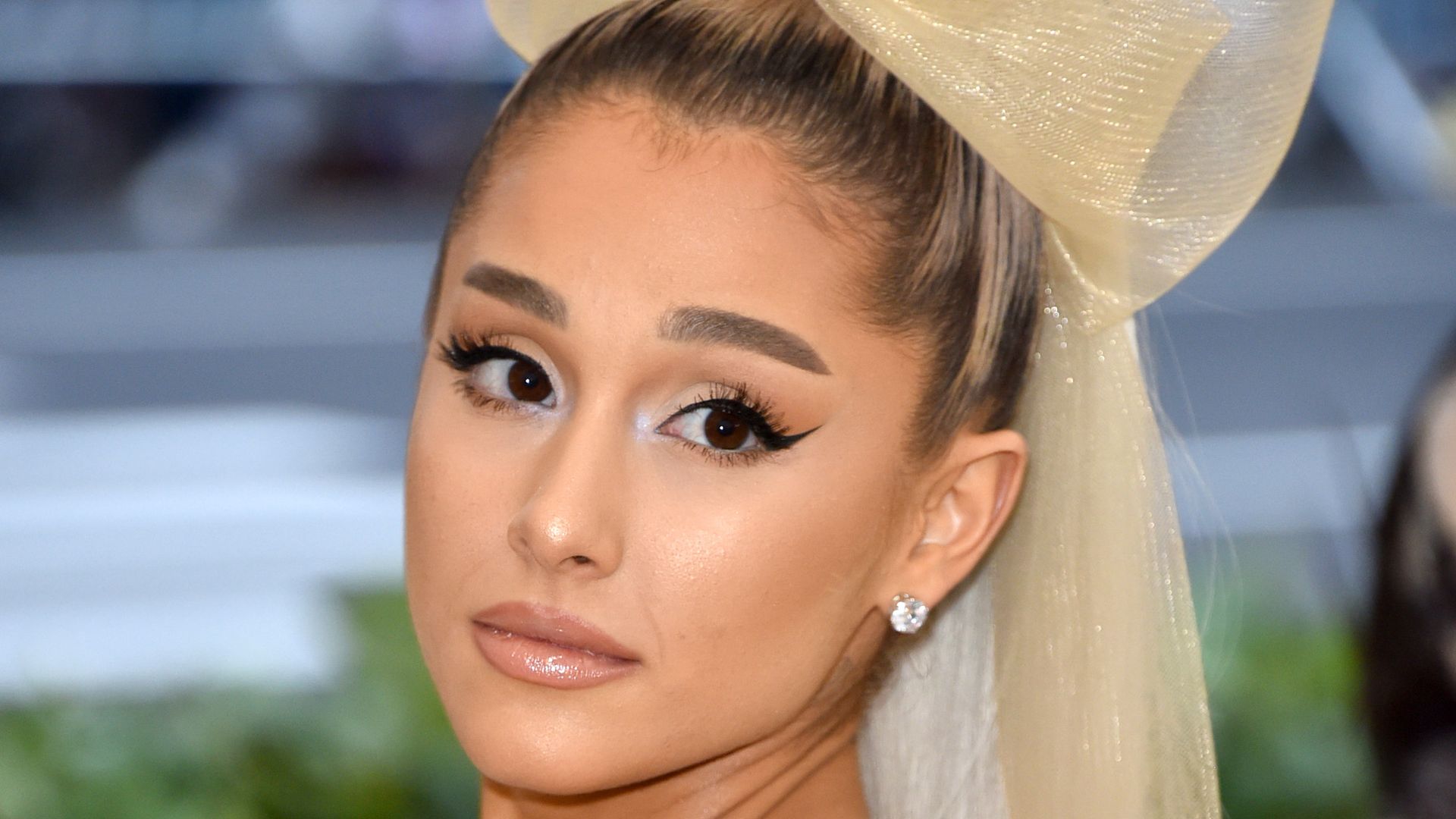 Ariana Grande  in strapless grey dress with bow in hair