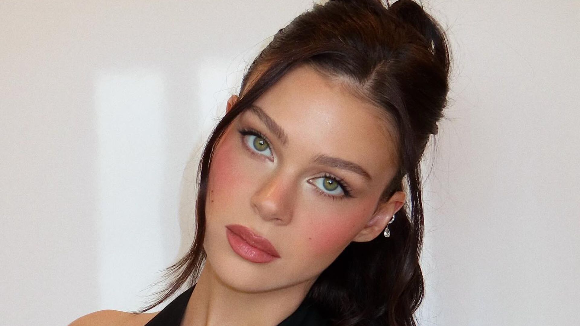 Nicola Peltz poses in a pluning black top