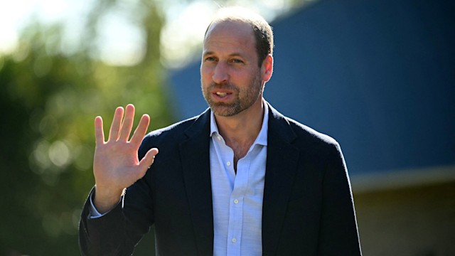 Prince William outside in a blue shirt and suit jacket