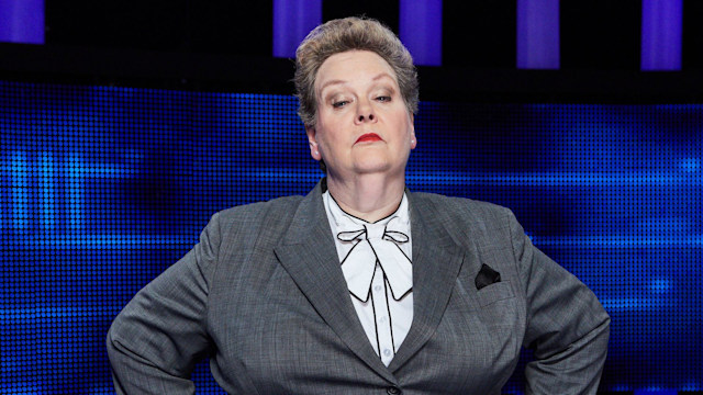 woman in grey suit with hands on hips in tv studio