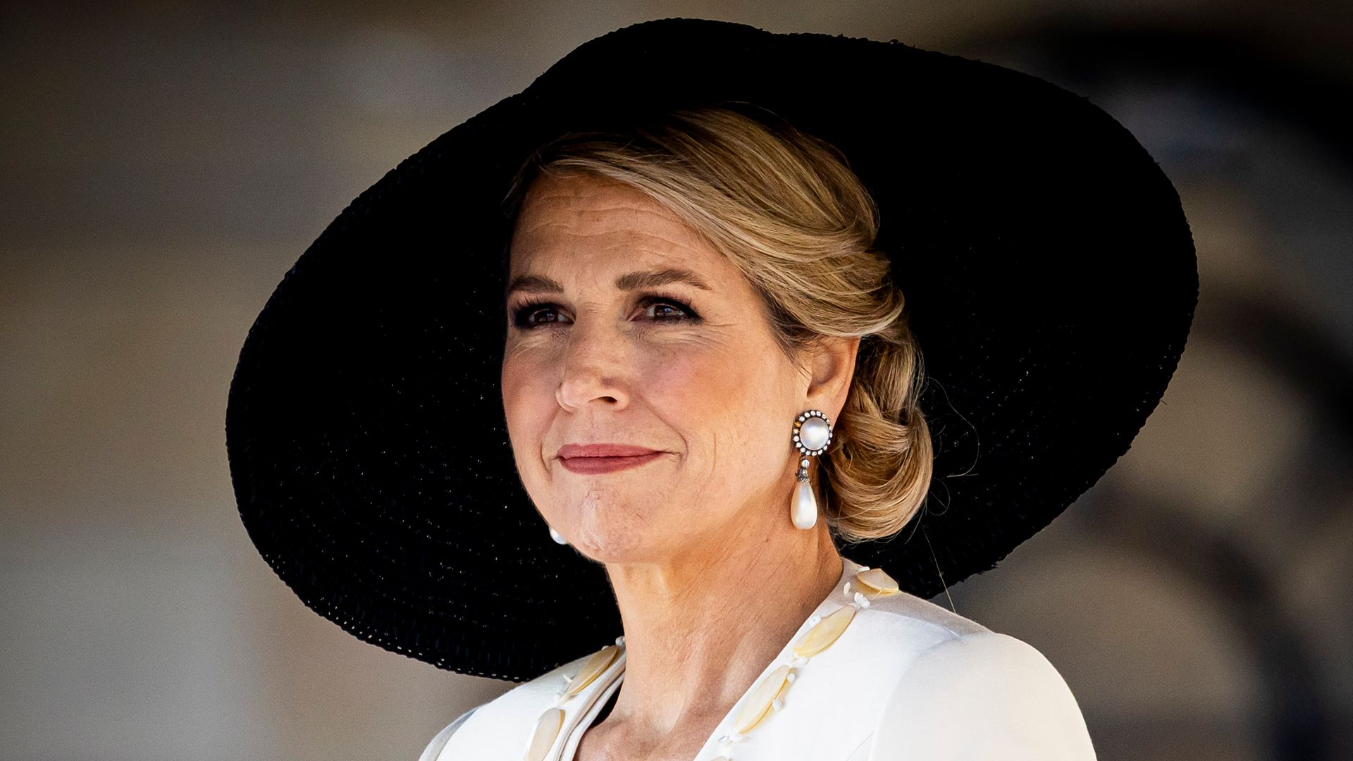 A photo of Queen Maxima wearing a black hat